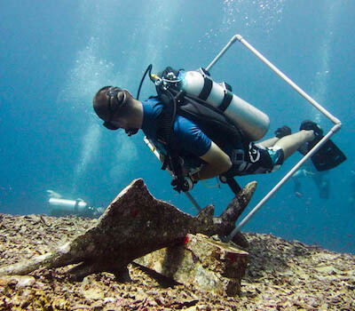 A diver swims through a hoop to practice buoyancy.