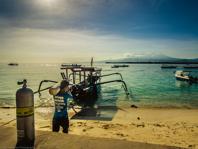 a diver carries tank to the boat 