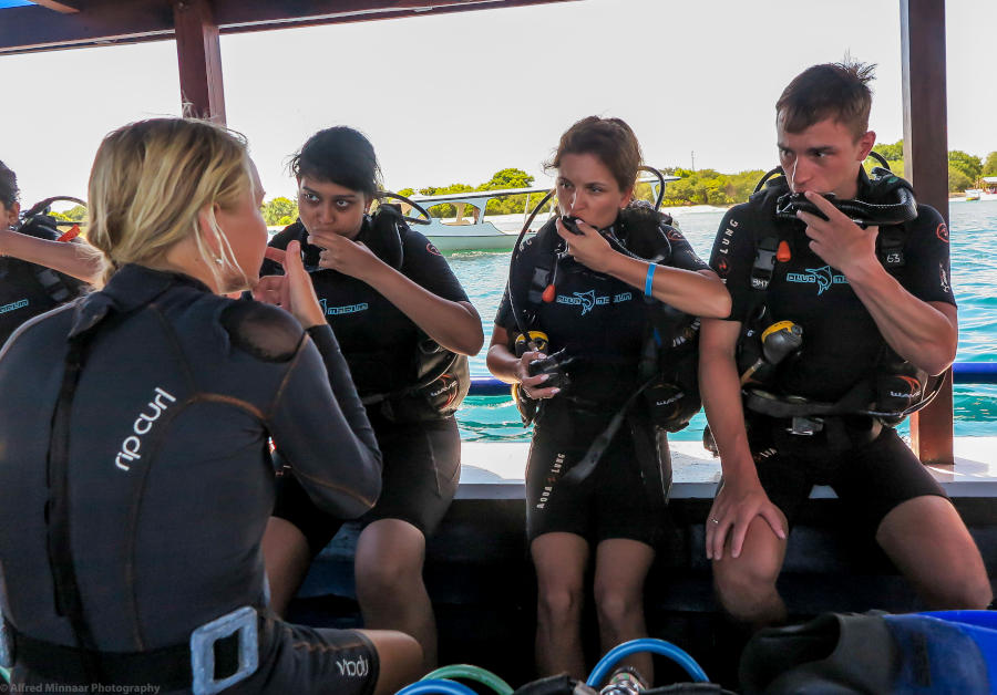 A diver carries her tank from the boat.